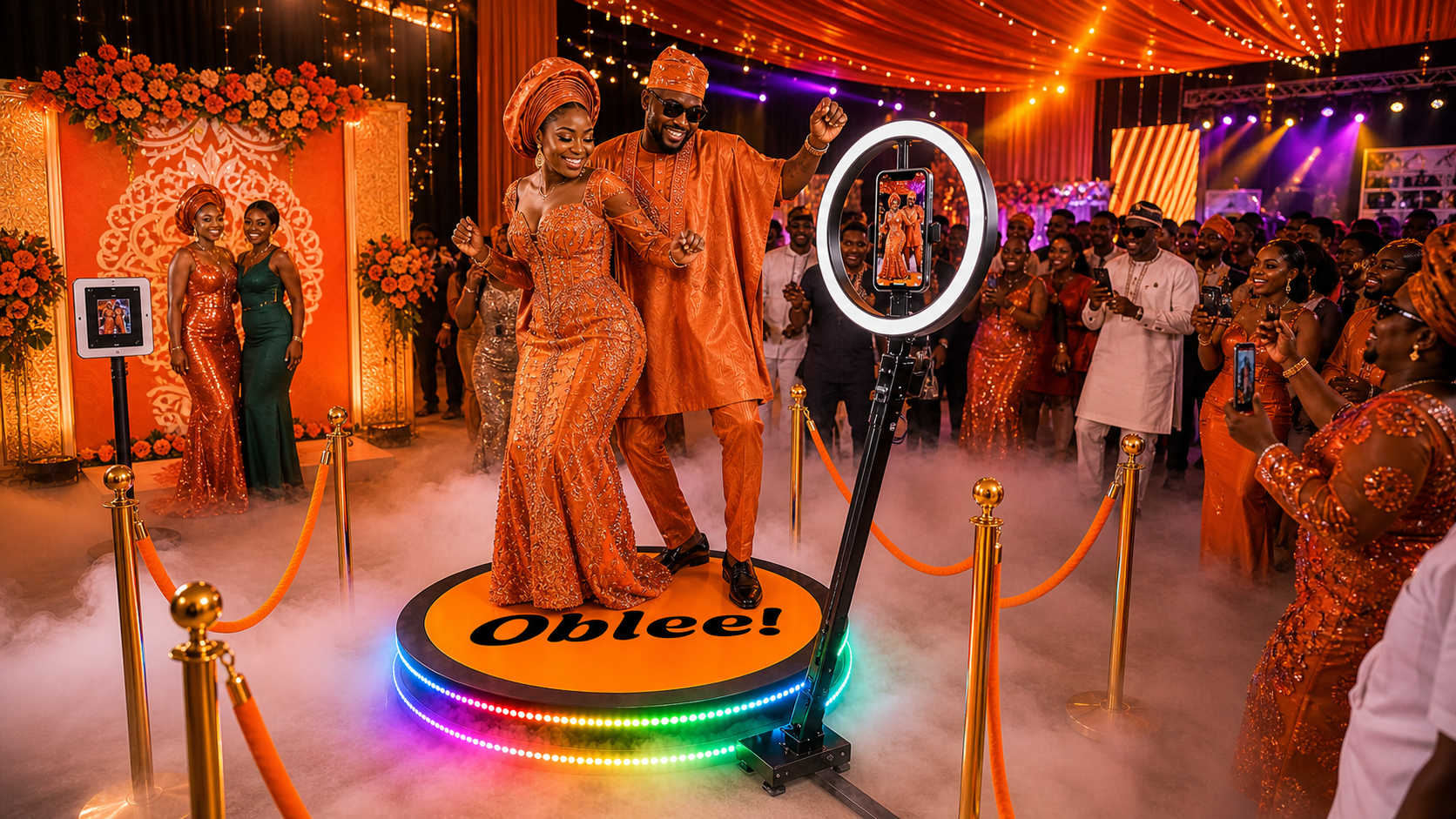 Couple celebrating on an Oblee 360 photobooth platform with Ankara backdrop